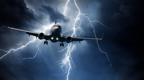 Passenger airplane travelling through sky against stormy bolt cloudscape